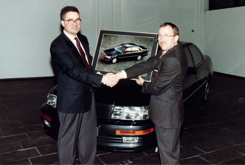 Burkhard Weller und TOYOTA Manager stehen vor dem ersten LEXUS LS in der Auto Weller-Ausstellungshalle