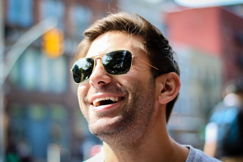 Mann mit Sonnenbrille lacht
